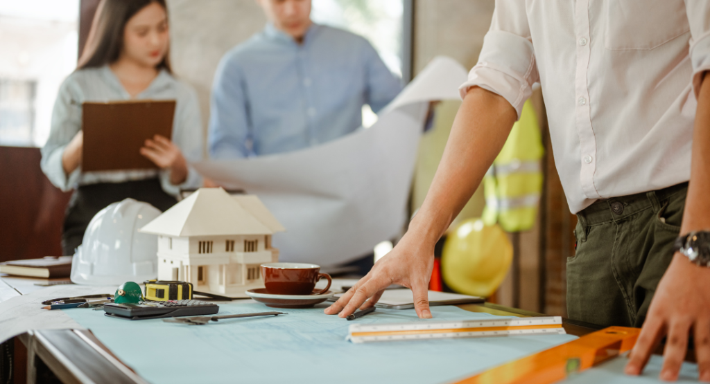 Trabalhadores aplicando a gestão de projetos de engenharia em construtoras