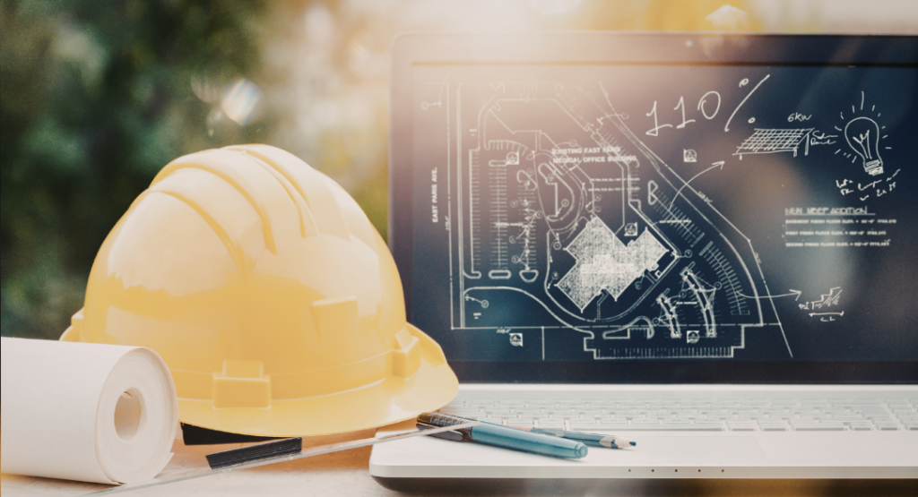 Notebook exibindo planejamento digital de engenharia ao lado de um capacete amarelo, representando a aplicação do value stream mapping na gestão de obras.
